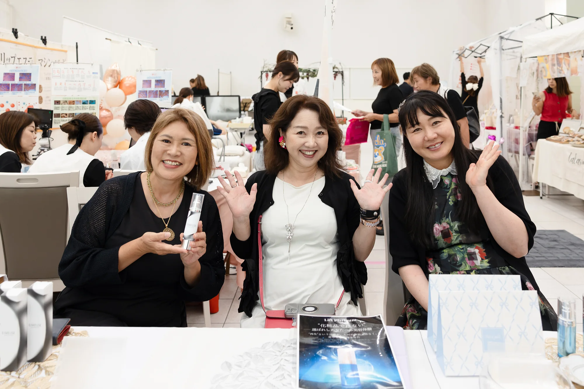 会場で商品を手に笑顔を見せる来場者たち